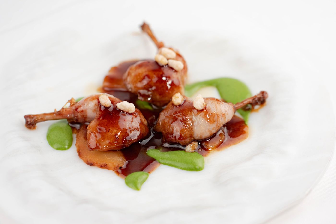 Glazed quail lollipops with green herb sauce