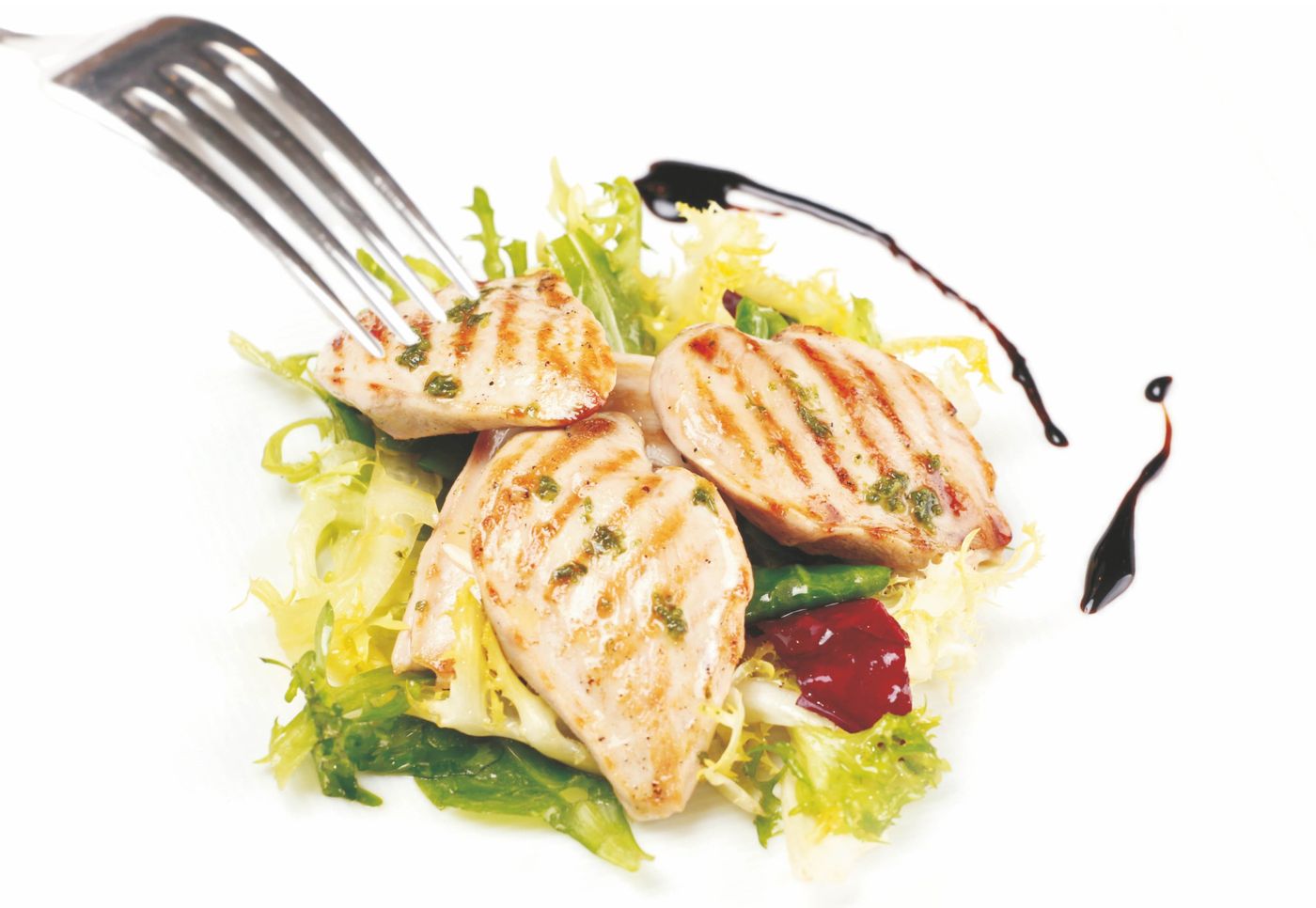 Grilled quail breasts over a green salad