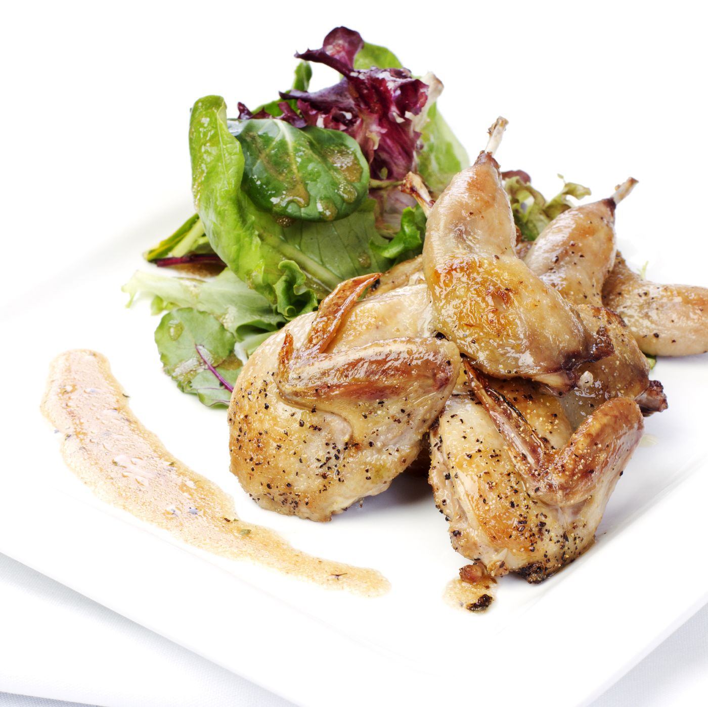 Roasted quail with mixed greens and pan sauce